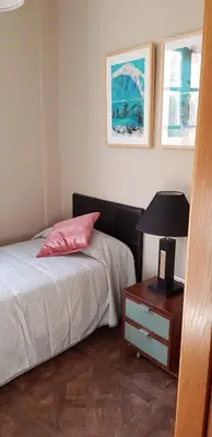 a bedroom with a bed and a table with a lamp at LA CASA DE HERACLES CADIZ in Cádiz