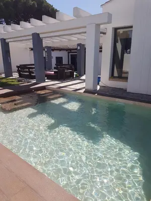 a swimming pool in front of a house at Villa chillout la barrosa in Chiclana de la Frontera