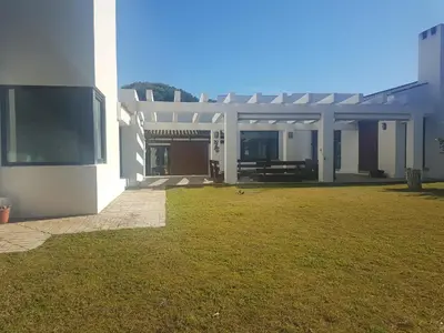 a house with a grass yard in front of it at Villa chillout la barrosa in Chiclana de la Frontera