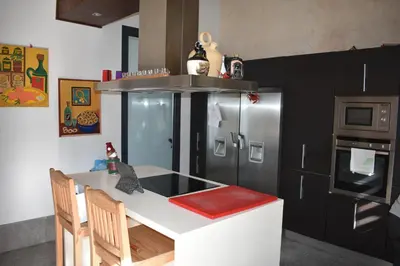 a kitchen with a white counter and a refrigerator at Villa chillout la barrosa in Chiclana de la Frontera
