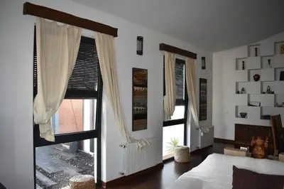a bedroom with two windows with curtains and a bed at Villa chillout la barrosa in Chiclana de la Frontera