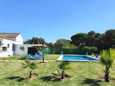 a backyard with a swimming pool and palm trees at Casa Rural El Pinar de Jesus in Arcos de la Frontera
