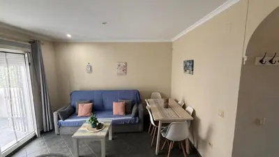 a living room with a blue couch and a table at Apartamento en La Almadraba in Chiclana de la Frontera