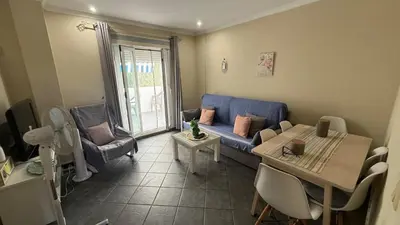 a living room with a blue couch and a table at Apartamento en La Almadraba in Chiclana de la Frontera