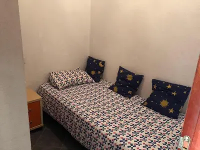 a bedroom with two beds with blue and yellow pillows at Apartamento en La Almadraba in Chiclana de la Frontera