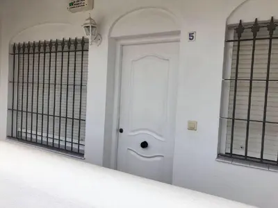 a white door in a room with two windows at Apartamento en La Almadraba in Chiclana de la Frontera