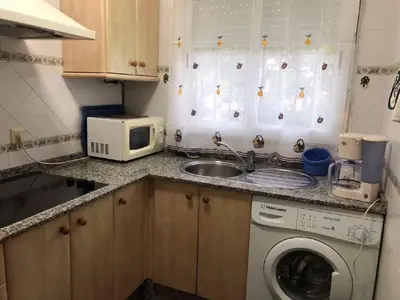 a kitchen with a washing machine and a microwave at Apartamento en La Almadraba in Chiclana de la Frontera
