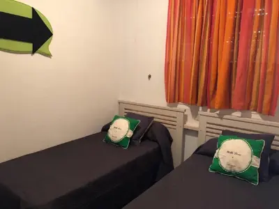 a bedroom with two beds with green pillows and a window at Apartamento en La Almadraba in Chiclana de la Frontera