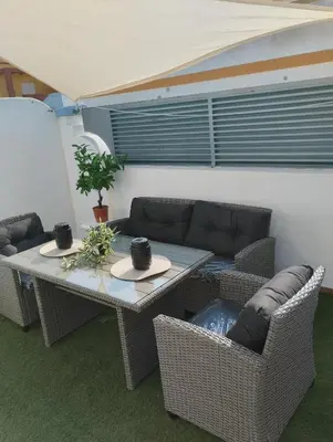 a patio with a table and chairs and a couch at Apartamento Rotasol in Rota