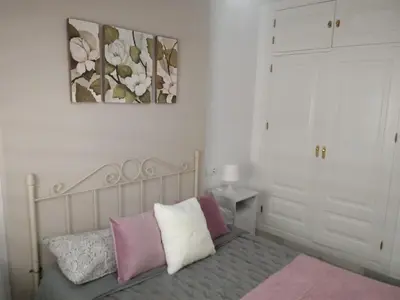 a bedroom with a bed with pink and white pillows at Apartamento Rotasol in Rota