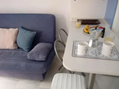 a living room with a blue couch and a table at Apartamento Rotasol in Rota