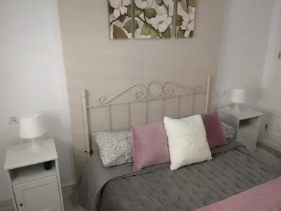 a bedroom with a bed with three pillows on it at Apartamento Rotasol in Rota