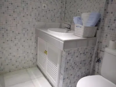 a bathroom with a white sink and a toilet at Apartamento Rotasol in Rota