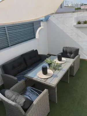 a patio with two tables and chairs and a couch at Apartamento Rotasol in Rota