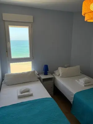 two beds in a room with a window at GAVIOTA Family Home free parking by Cadiz4Rentals in Cádiz