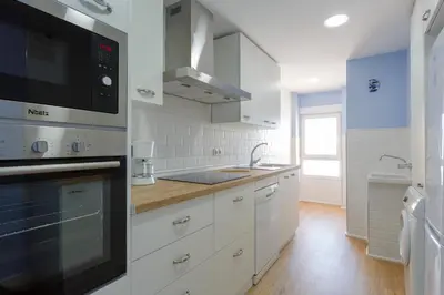 a white kitchen with a sink and a microwave at GAVIOTA Family Home free parking by Cadiz4Rentals in Cádiz