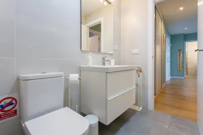 a white bathroom with a toilet and a sink at GAVIOTA Family Home free parking by Cadiz4Rentals in Cádiz