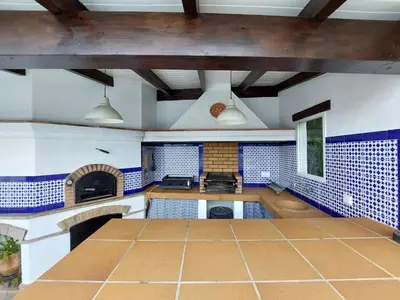 a large kitchen with blue and white tiles on the walls at Villa El Estanque Holiday Cottage & Bungalow in Arcos de la Frontera