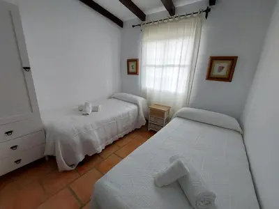 a bedroom with two beds and a window at Villa El Estanque Holiday Cottage & Bungalow in Arcos de la Frontera