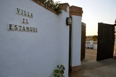 a white building with a sign on the side of it at Villa El Estanque Holiday Cottage & Bungalow in Arcos de la Frontera