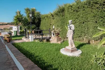 a statue of a man standing in the grass at Villa El Estanque Holiday Cottage & Bungalow in Arcos de la Frontera