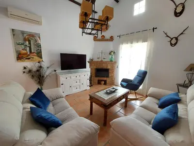 a living room with a white couch and blue pillows at Villa El Estanque Holiday Cottage & Bungalow in Arcos de la Frontera