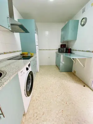 a kitchen with blue cabinets and a washing machine at La Araucaria de Chipiona in Chipiona