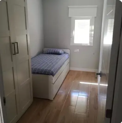 a small bedroom with a bed and a window at Bonito piso in Puerto Real