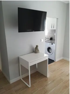 a white table with a tv on a wall at Bonito piso in Puerto Real