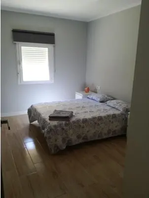 a bedroom with a bed and a window at Bonito piso in Puerto Real