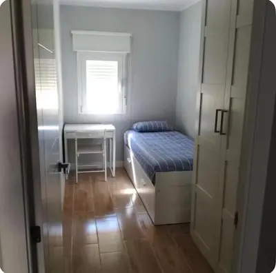 a small bedroom with a bed and a window at Bonito piso in Puerto Real