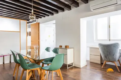 a dining room with a glass table and green chairs at Diana de Columela by Cadiz Time in Cádiz