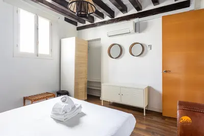 a bedroom with a white bed and two mirrors at Diana de Columela by Cadiz Time in Cádiz