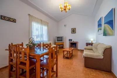 a living room with a dining room table and a couch at Chalet Pedro I in Conil de la Frontera