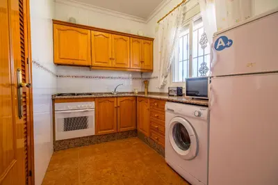 a kitchen with a white refrigerator and a dishwasher at Chalet Pedro I in Conil de la Frontera