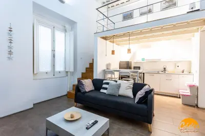 a living room with a couch and a kitchen at Casa Isabela by Cadiz Time in Cádiz