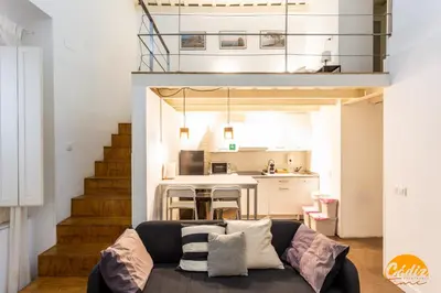 a living room with a couch and a kitchen at Casa Isabela by Cadiz Time in Cádiz