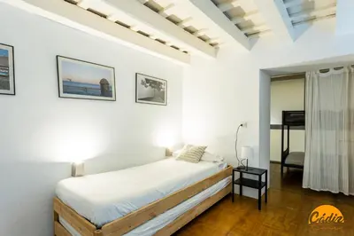 a white bedroom with a bed and a mirror at Casa Isabela by Cadiz Time in Cádiz
