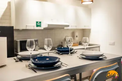 a kitchen with a table with plates and wine glasses at Casa Isabela by Cadiz Time in Cádiz