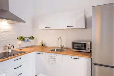 a white kitchen with a sink and a microwave at Apartamento Cádiz Centro Blue Window in Cádiz