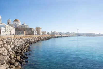 a group of rocks on the side of a body of water at Apartamento Cádiz Centro Blue Window in Cádiz
