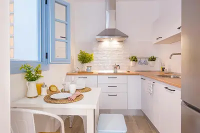 a white kitchen with a table and a sink at Apartamento Cádiz Centro Blue Window in Cádiz