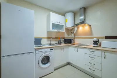a kitchen with white cabinets and a washer and dryer at Apartamento Vista Azul in Costa Ballena