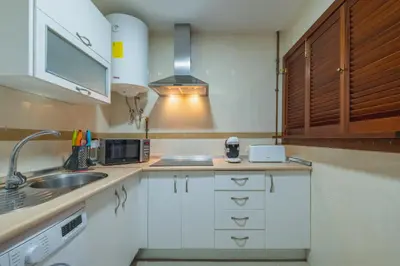 a kitchen with white cabinets and a sink at Apartamento Vista Azul in Costa Ballena