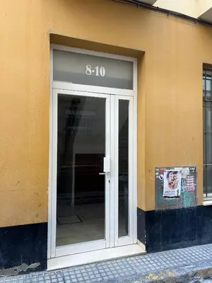 a glass door of a building with a sign on it at Rinconcito del Falla Grupo AC Gestion in Cádiz