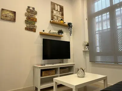 a living room with a flat screen tv on a wall at Rinconcito del Falla Grupo AC Gestion in Cádiz