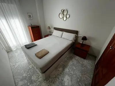 a bedroom with a large white bed and a window at Las Gemelas de Benjumeda en la Caleta Grupo AC Gestion in Cádiz