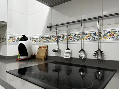 a kitchen with utensils hanging on the wall at Las Gemelas de Benjumeda en la Caleta Grupo AC Gestion in Cádiz