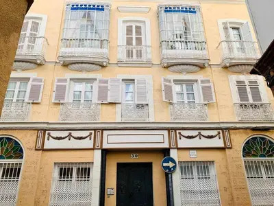 a yellow building with white windows and a door at Las Gemelas de Benjumeda en la Caleta Grupo AC Gestion in Cádiz