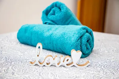 a blue towel on a bed with a word love at VALDECARRETAS Apartamento Rota cerca de playa in Rota